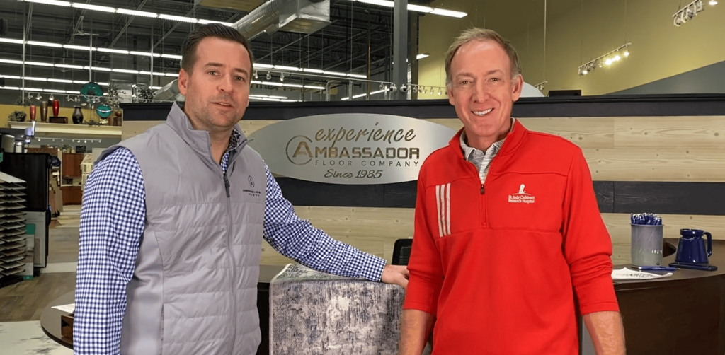 Employees standing in front of company logo