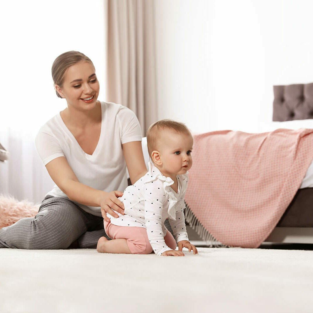 Mom and baby sitting on carpet floor | Ambassador Flooring